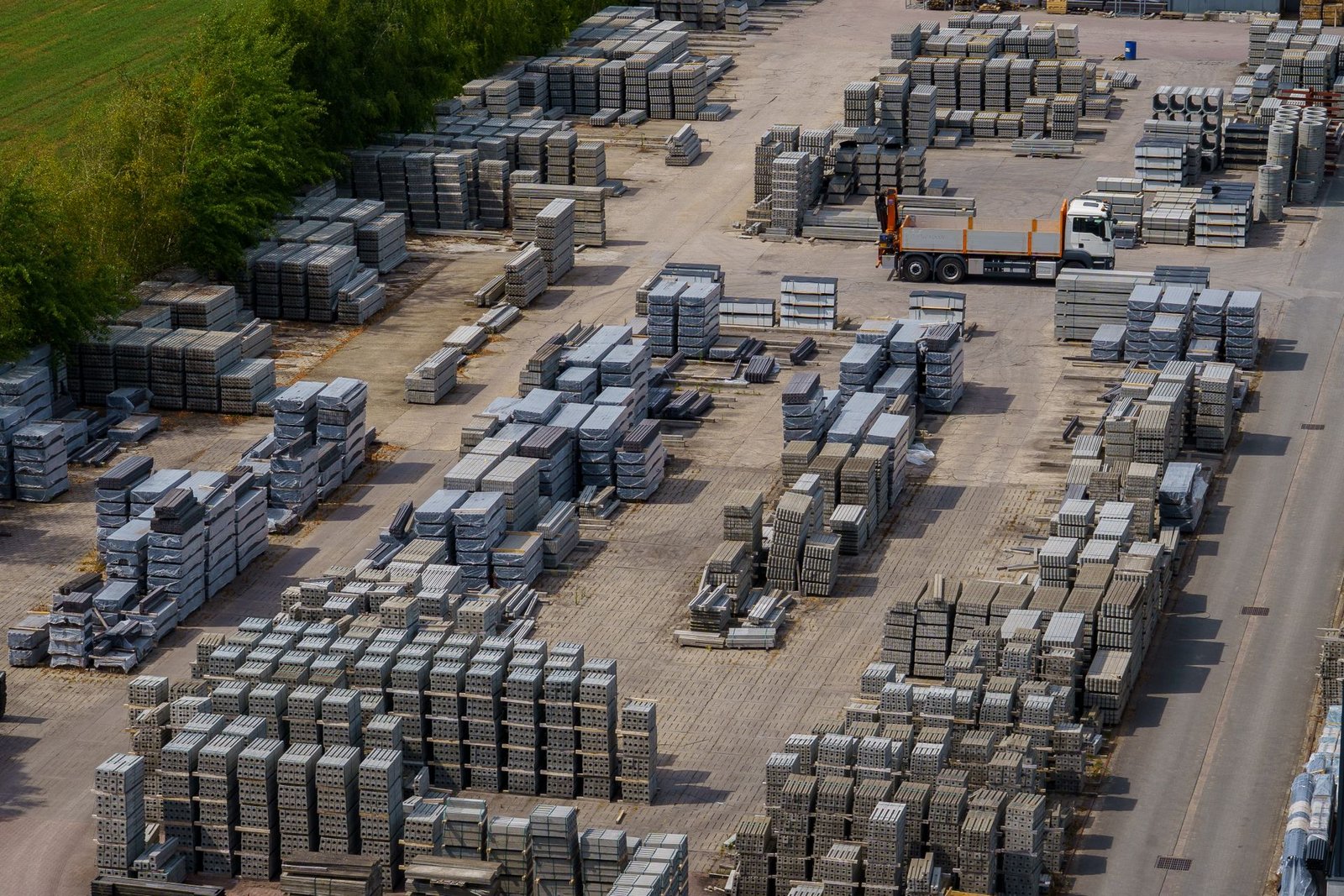 Building materials yard with stacked bricks and a truck